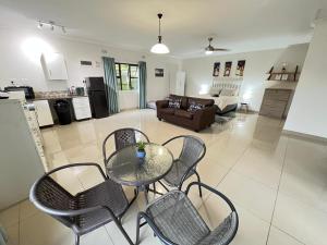 een woonkamer met een glazen tafel en stoelen bij Ukosi Brisa in Kloof