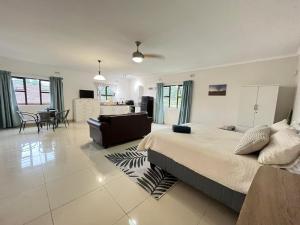 een slaapkamer met een groot bed en een woonkamer bij Ukosi Brisa in Kloof