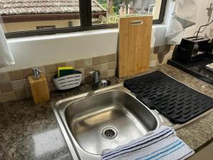 een roestvrijstalen wastafel in een keuken met een raam bij Ukosi Brisa in Kloof +59 foto's