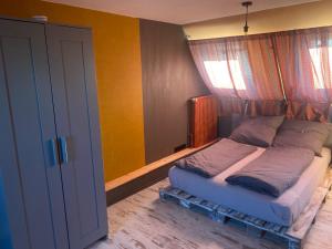 ein kleines Bett in einem Zimmer mit Fenster in der Unterkunft Charmante Fachwerkhaushälfte mit Sauna in Rosche