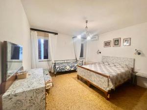 a bedroom with two beds and a table at L'ENCANTO DE LUNA -Una Casa Autentica Comacchiese in Comacchio