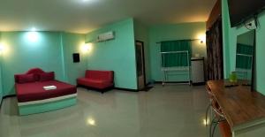 - un salon avec un canapé rouge et une chaise dans l'établissement โรงแรมโรแมนติก2, 