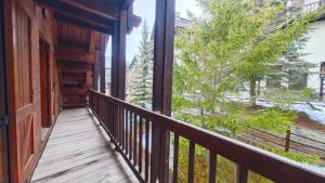un balcon d'un chalet en rondins avec vue sur un arbre dans l'établissement Hostdomus- Abeti Apartments, à Sestrières
