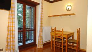une salle à manger avec une table et une fenêtre dans l'établissement Hostdomus- Abeti Apartments, à Sestrières