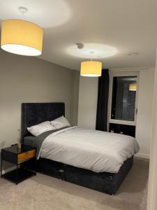 een slaapkamer met een groot bed met 2 verlichting bij Chalk in Moffat