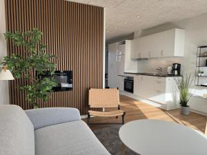 a living room with a couch and a kitchen at HYGGE Strand Camping in Odder
