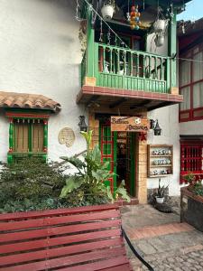 a building with a balcony and a shop with a red fence at Monguí Posada Familiar in Duitama