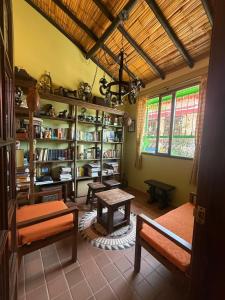 un salon avec des bancs, une table et des étagères à livres dans l'établissement Monguí Posada Familiar, à Duitama 19 autres photos