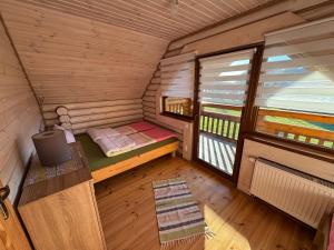 an inside view of a cabin with a bed and a window at Sosnowe Domki in Rewal