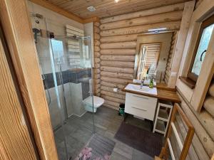 a bathroom with a shower and a sink and a toilet at Sosnowe Domki in Rewal +79 photos