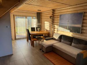 a living room with a couch and a desk at Sosnowe Domki in Rewal