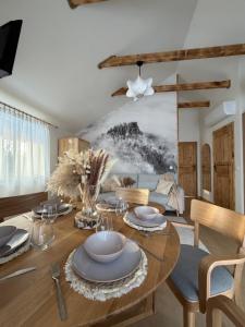 een eetkamer met een houten tafel met borden en bestek bij Markowa Chata in Mizerna