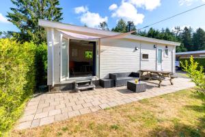 a small house with a patio and a picnic table at Boshuisje Dille te Veluwe in Putten