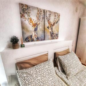 due quadri di cervi su un muro sopra un letto di Garden apartment a Karlovo