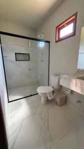 a bathroom with a glass shower and a toilet at Vila Gaheri in São Miguel dos Milagres