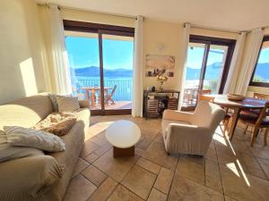 a living room with a couch and chairs and a table at Lago Maggiore - Traumbalkon mit Seeblick & Pool und 2 SZ in Oggebbio