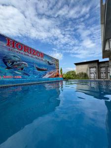 a large swimming pool with blue water in front of a building at Horizon cottage in Nagaon