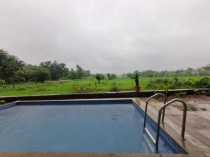 a swimming pool with a view of a field at Horizon cottage in Nagaon