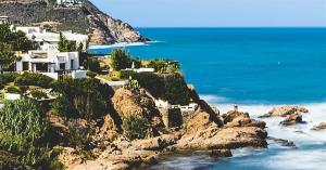 a house on top of a cliff next to the ocean at Ray CaboNegro Sea & Pool View in Cabo Negro