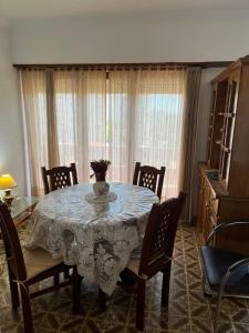 un tavolo da pranzo con sedie e un vaso sopra di Depto 1 amb 2 personas miramar 3 noches mínimo a Miramar