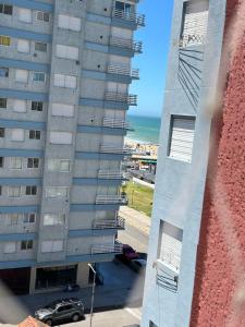 un edificio alto con una macchina parcheggiata di fronte di Depto 1 amb 2 personas miramar 3 noches mínimo a Miramar