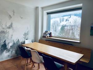a dining room with a wooden table and a window at Willa Makuchówka in Korbielów