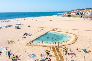een groep mensen in een zwembad op een strand bij Tonay Sol 7D in Buarcos