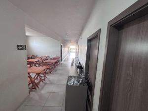 a corridor of a restaurant with tables and chairs at Hotel Master Plaza Formiga in Formiga