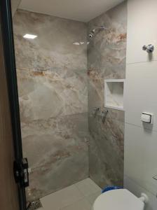 a bathroom with a marble shower with a toilet at Estrela de davi in Goiânia