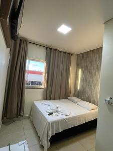 a bedroom with a large bed with a window at Estrela de davi in Goiânia