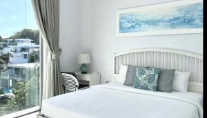 a white bedroom with a bed and a window at Penthouse Residence 8 Suite 2 in Nathon Bay