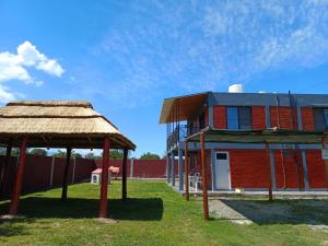 een gebouw met een rieten dak naast een gebouw bij Complejo soñado in Mina Clavero