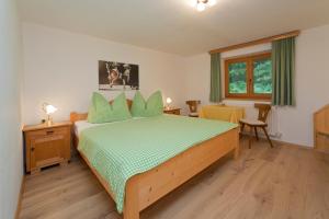 une chambre avec un lit, une table et des chaises dans l'établissement Haus Waldrand, à Oberndorf en Tyrol