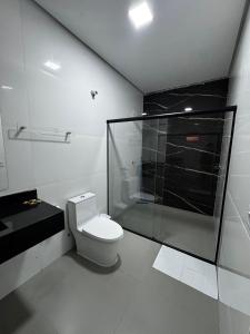 een badkamer met toilet en glazen douche bij Villa Hotel in Bom Jesus da Lapa