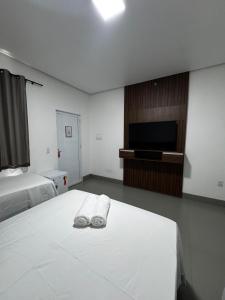 a hotel room with a bed and a flat screen tv at Villa Hotel in Bom Jesus da Lapa