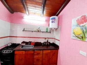 a small kitchen with a sink and a stove at Brisas de las Sierras in Tanti +3 photos