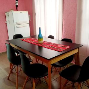 een tafel met stoelen en een vaas erop bij Brisas de las Sierras in Tanti +4 foto's