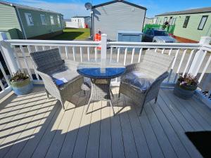 a patio with a table and chairs on a deck at Rendezvous at Ocean Edge in Heysham