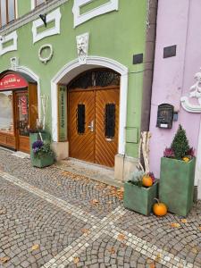 een voordeur van een gebouw met pompoenen voor de deur bij Apartmán GREEN in Vysoké Mýto