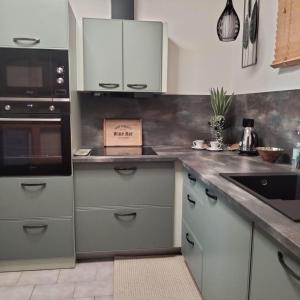 een keuken met witte kasten en een aanrechtblad bij Apartmán GREEN in Vysoké Mýto