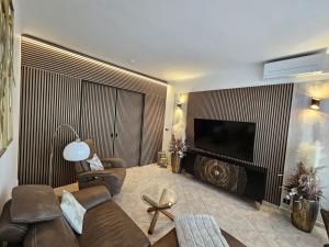 a living room with a couch and a flat screen tv at Apartmán GREEN in Vysoké Mýto