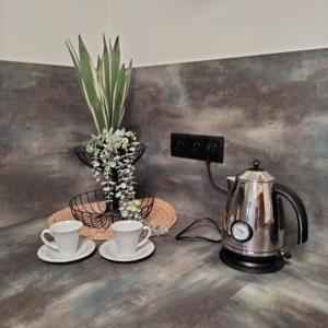 een tafel met twee kopjes en een waterkoker bij Apartmán GREEN in Vysoké Mýto +13 foto's