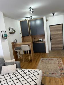 a living room with a table and a kitchen at Apartman MAD Bjelasnica in Bjelašnica