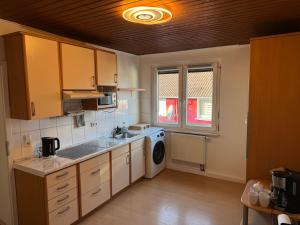 a kitchen with a sink and a washing machine at Gemütliche, lichtdurchflutete Wohnung in Karlsruhe