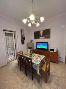 een eetkamer met een tafel en een tv bij Casa Cristina in Marino