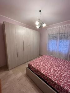 een slaapkamer met een bed, witte kasten en een kroonluchter bij Casa Cristina in Marino