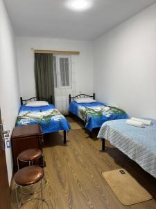 une chambre avec deux lits et deux tabourets dans l'établissement NAPO HOTEL სასტუმრო ნაპო, à Zugdidi