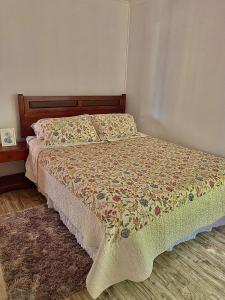 une chambre avec un lit avec un couvre-lit fleuri dans l'établissement Cabañas Vega del Molino, à Linares