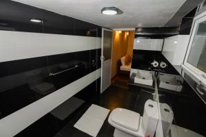 a black and white bathroom with two sinks and a toilet at Anaya Villa in Nuwara Eliya +39 photos