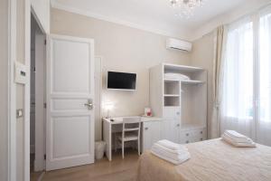 een witte slaapkamer met een bureau en een bed bij Opera Relais in Messina